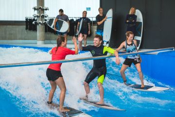 Drei Anfänger surfen auf der Indoor Welle