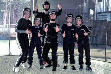 Eine Gruppe von Kinder ist in dem Windkanal in der Jochen Schweizer Arena
