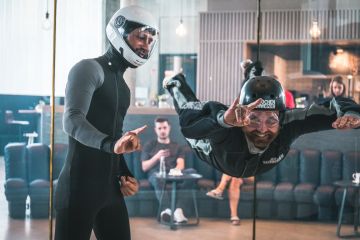 Ein Instructor und ein Gast sind im Windkanal in der Jochen Schweizer Arena