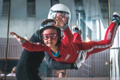 Ein Instructor und ein Kind in dem WIndtunnel der Jochen Schweizer Arena